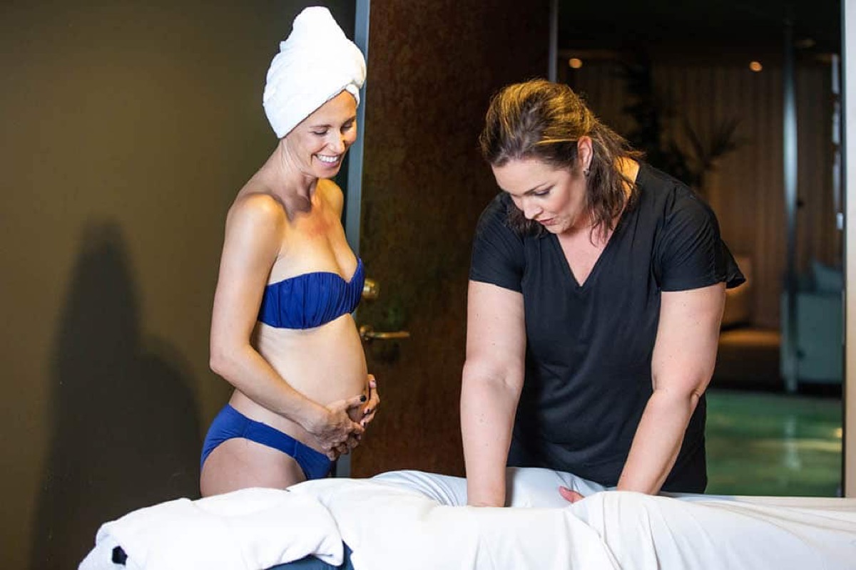 Gravid kvinna vid massagebänken med en terapeut på Hagabadet